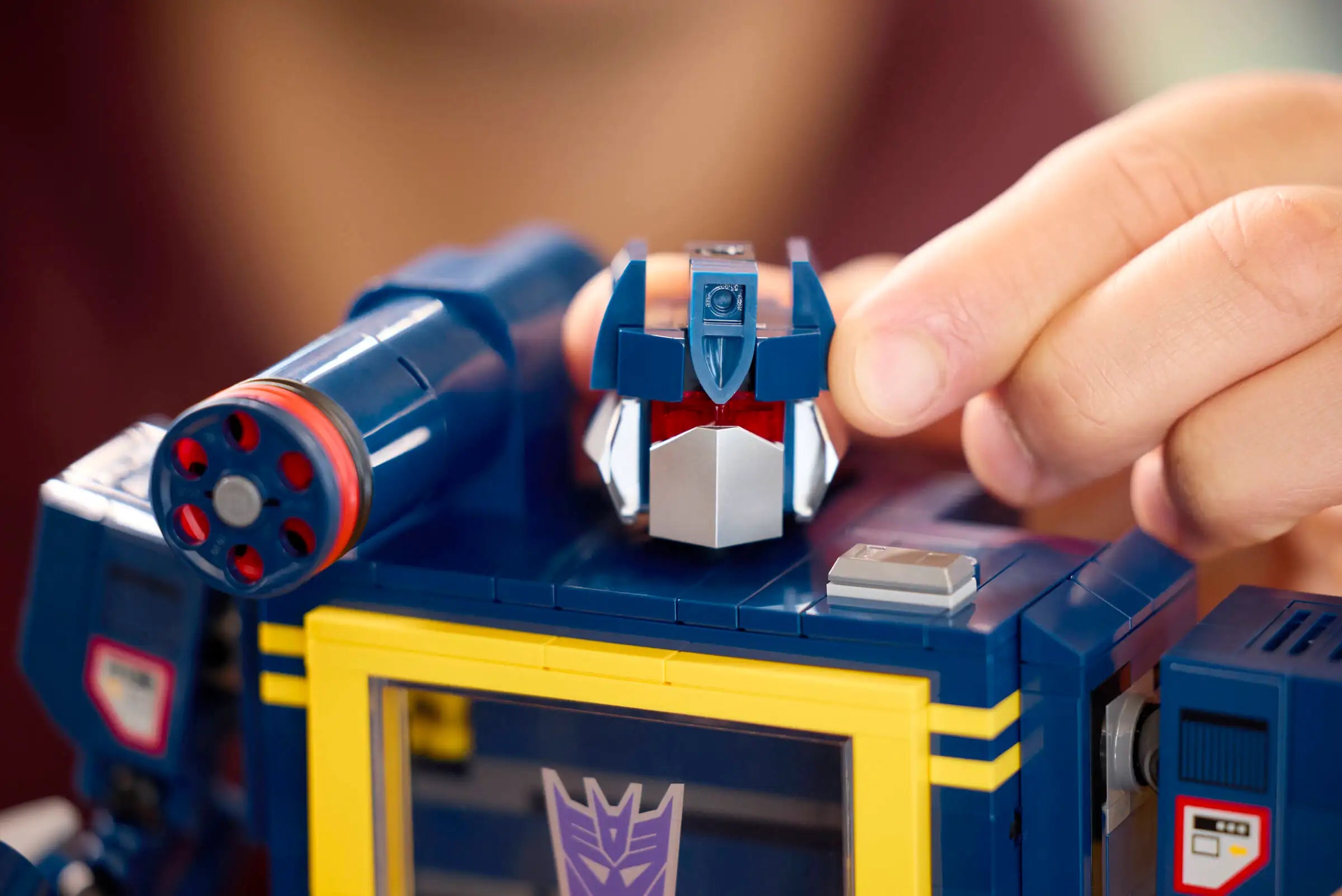 Hand interacting with LEGO 10358 Transformers: Soundwave
