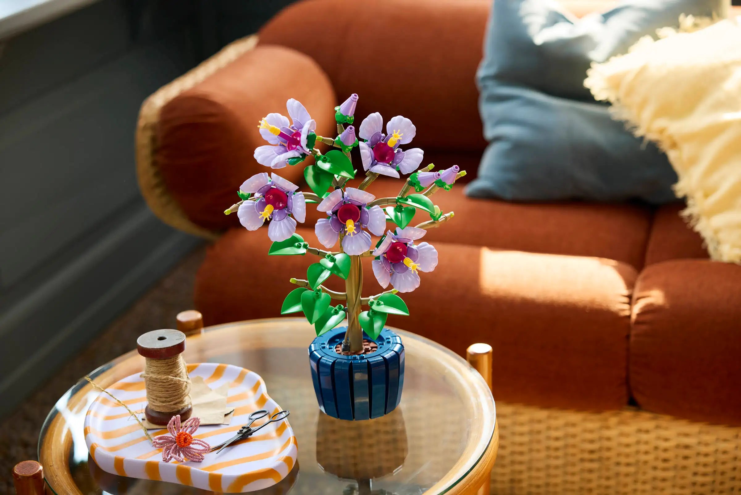 LEGO 10372 Hibiscus on a small table with a couch in the background