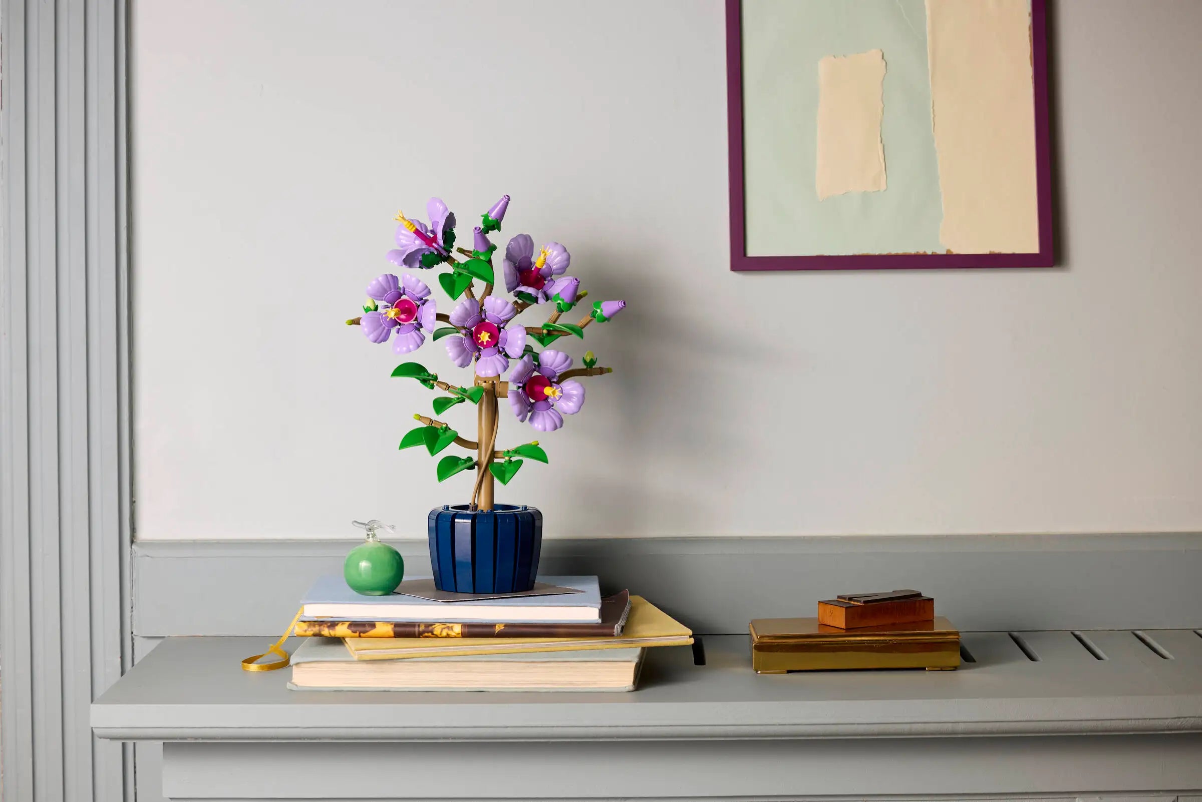 LEGO 10372 Hibiscus on books with a framed picture on the wall