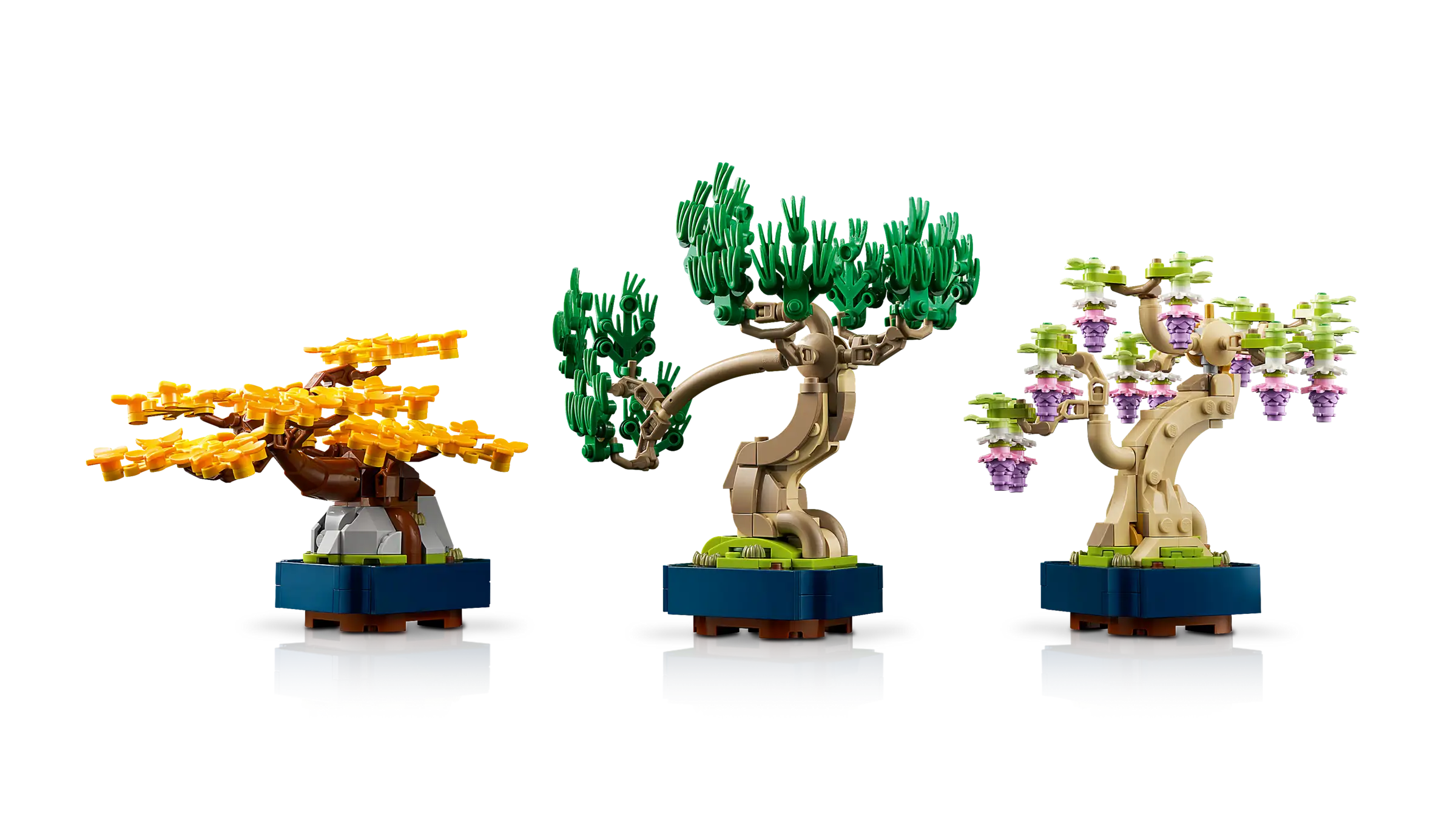 Three LEGO bonsai trees on a white background