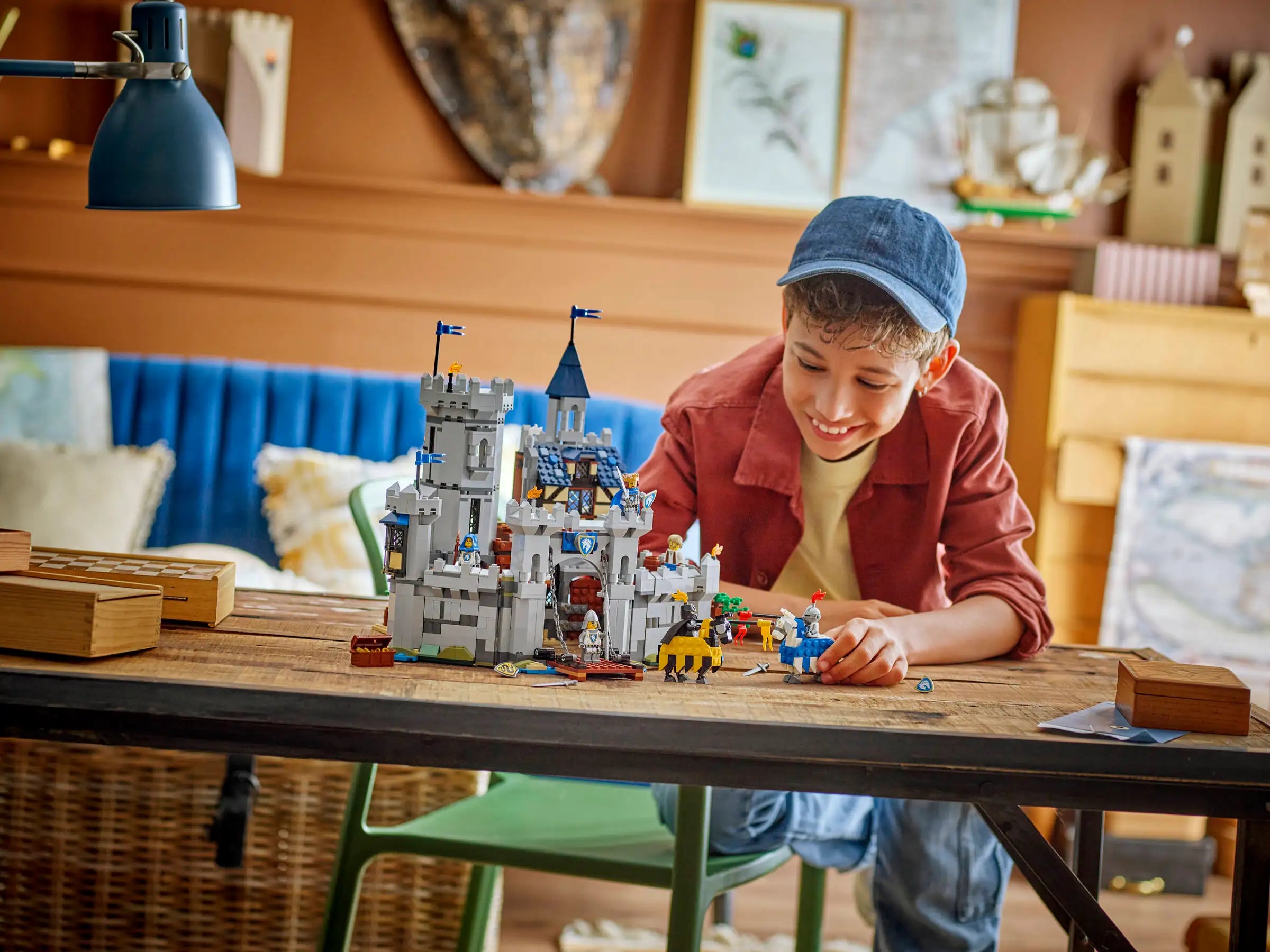 Child playing with a LEGO 31168 Medieval Horse Knight Castle set at a table in a cozy room.