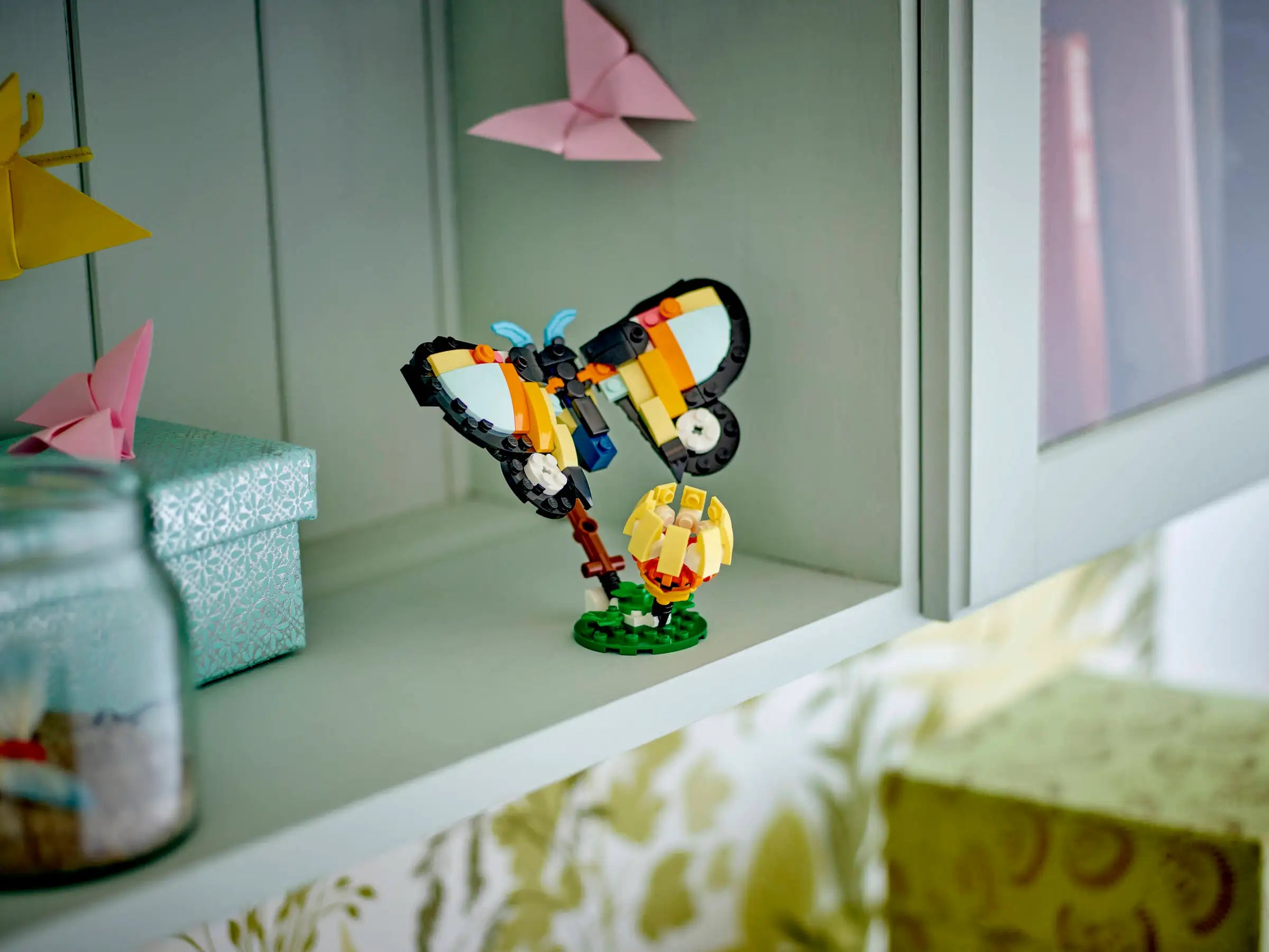 LEGO butterfly model on a shelf with decorative items