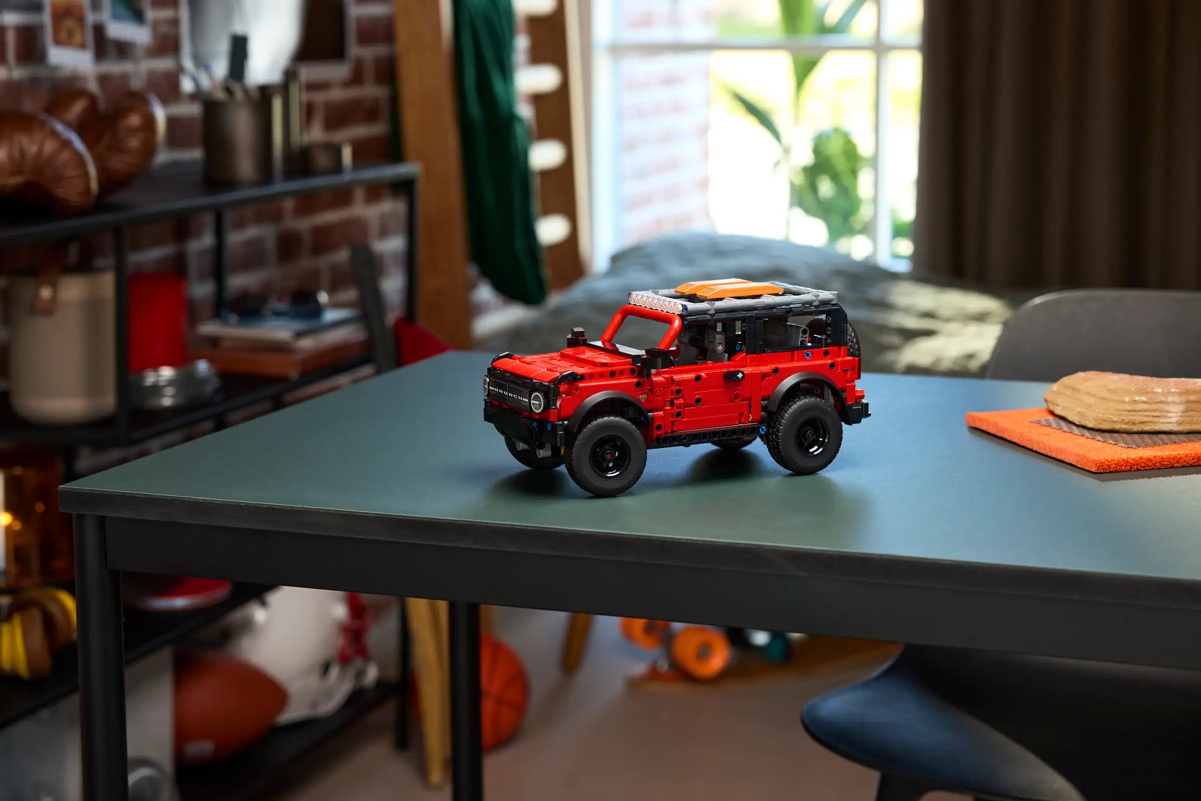 LEGO 42213 Ford Bronco SUV on a table in a room with a window and furniture.