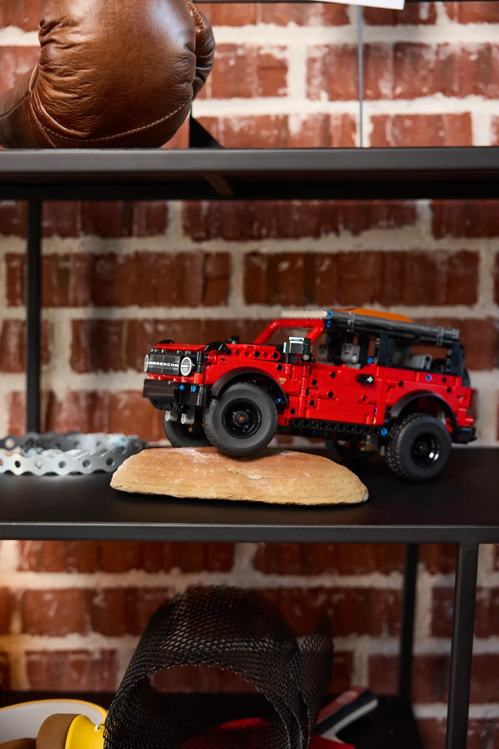 LEGO 42213 Ford Bronco SUV on a wooden block with a brick wall background