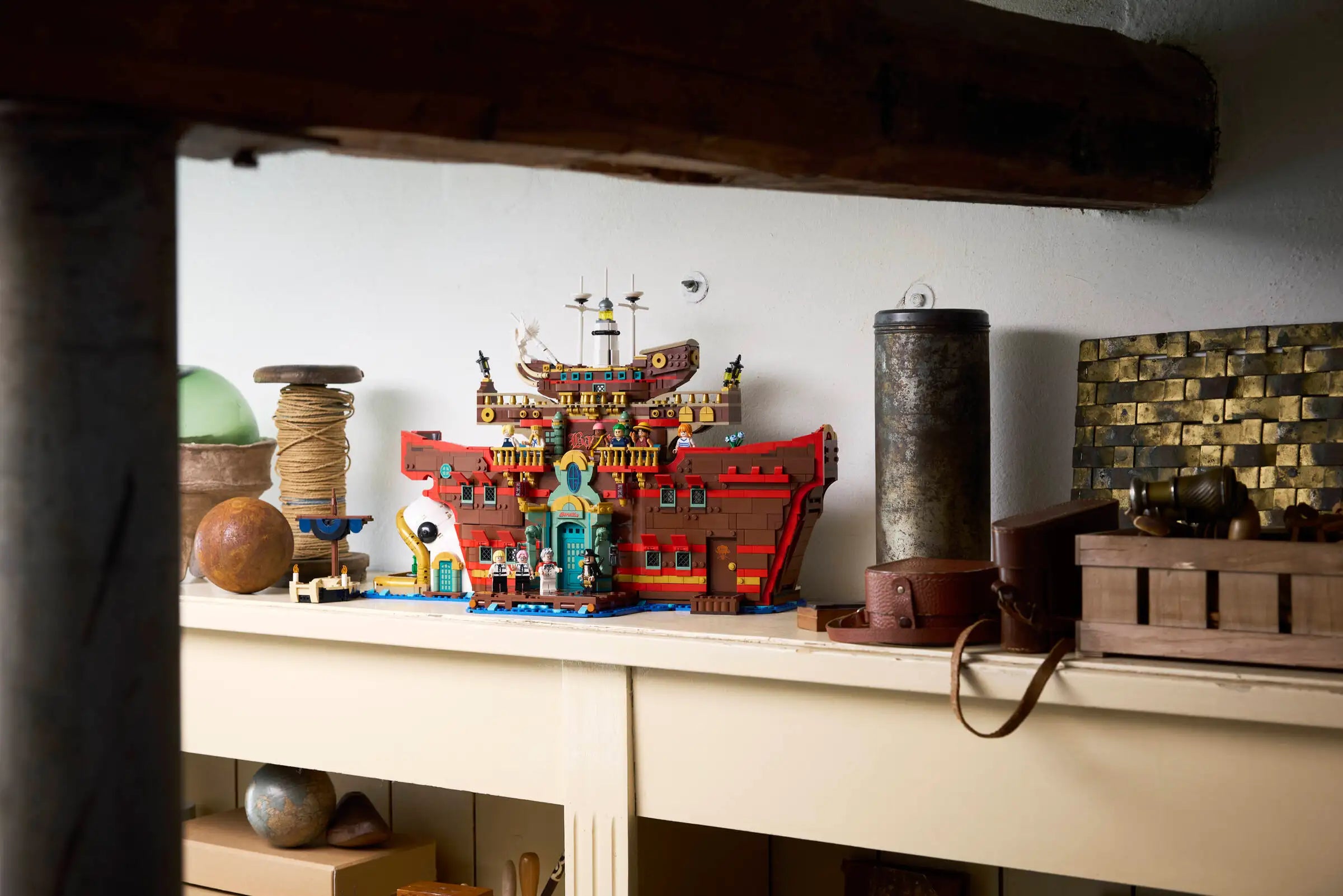 LEGO 75640 The Baratie Floating Restaurant on a shelf with various items including a crate and a clock.