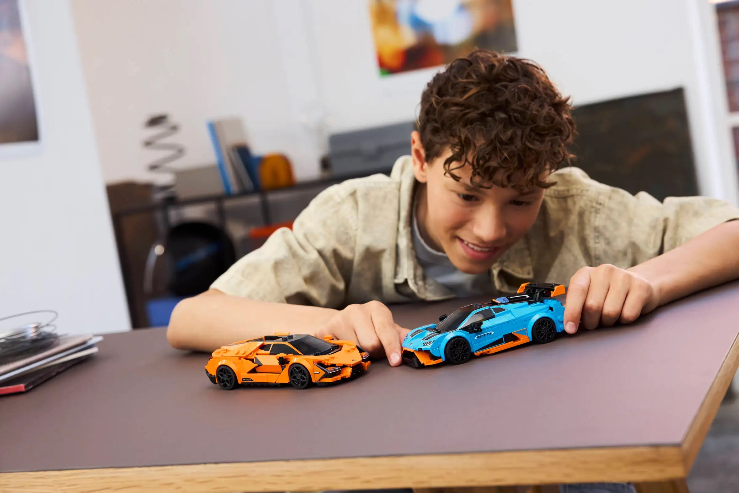 Child playing with LEGO 77238 Lamborghini Revuelto & Lamborghini Huracán STO toy cars on a table in a room setting