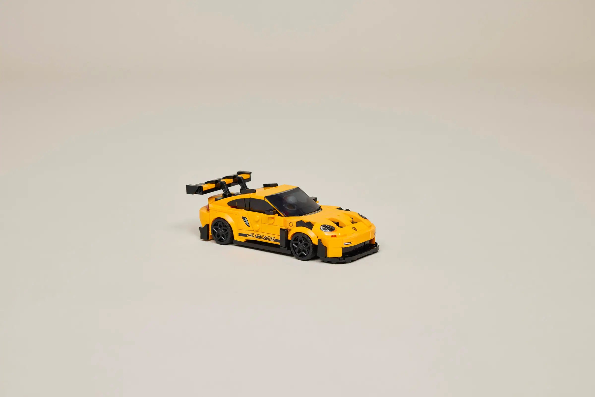 LEGO 77239 Porsche 911 GT3 RS Yellow toy car on a beige background