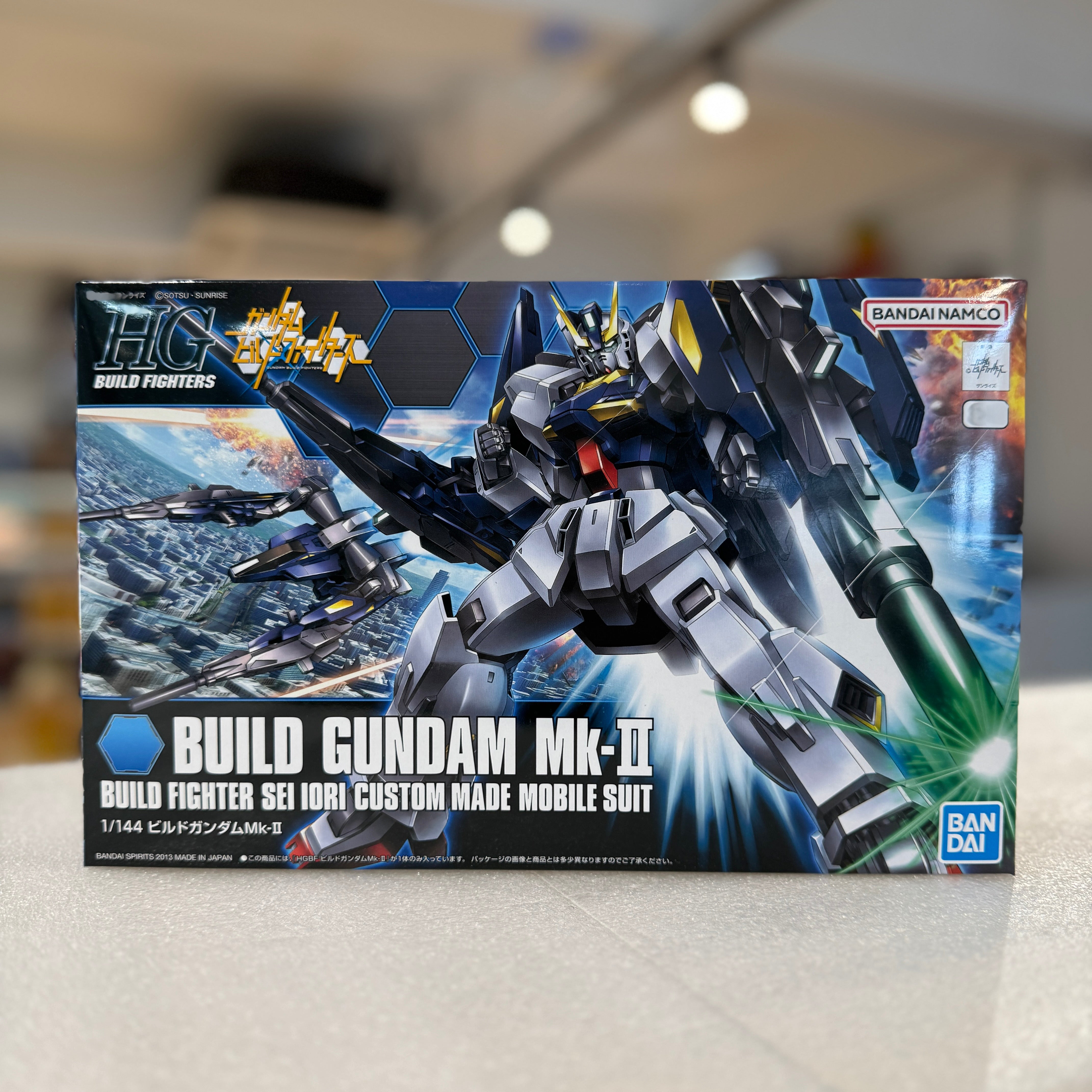 Model kit box for Build Gundam Mk-II with detailed artwork on a blurred background