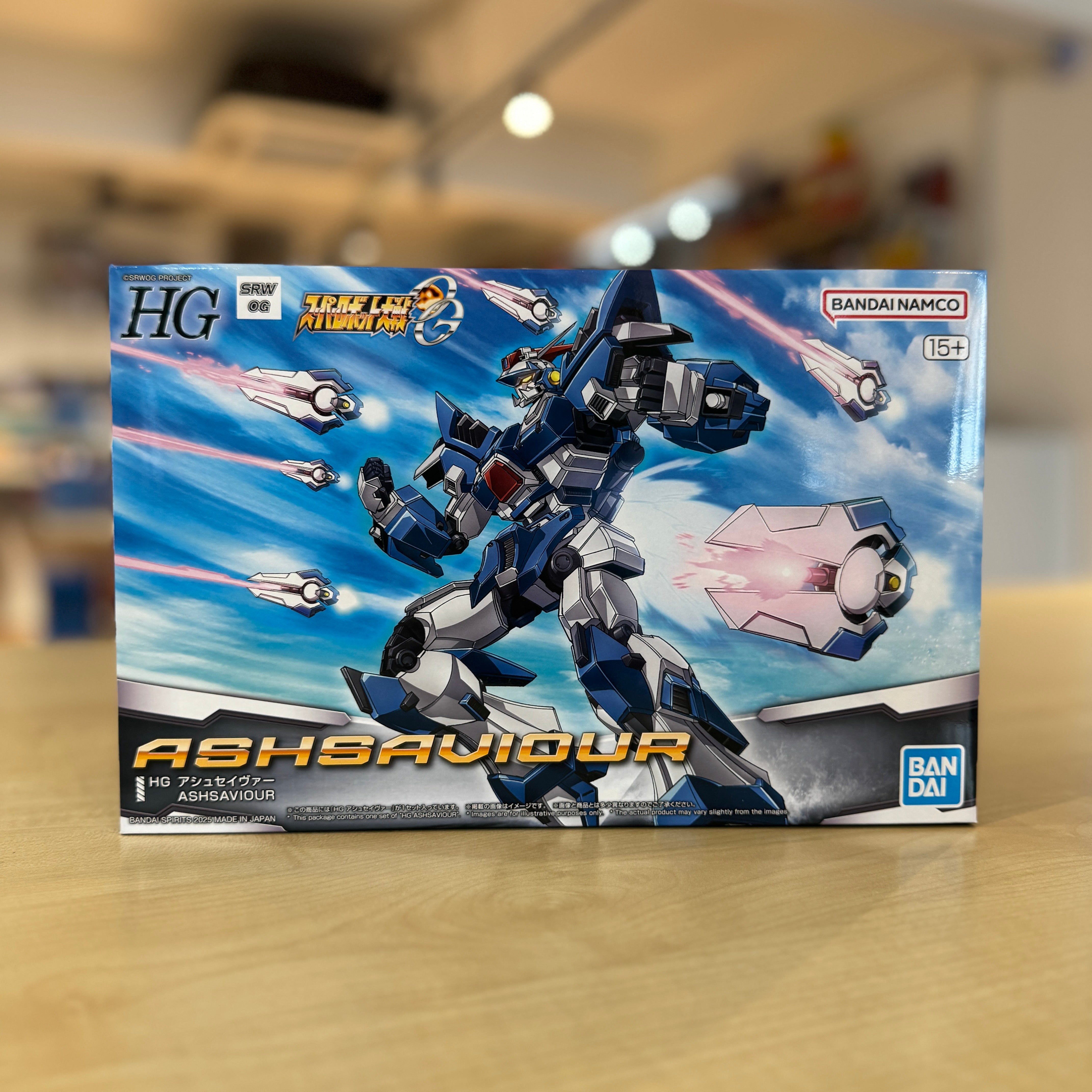 Box of a robot model kit with 'ASHSAVIOUR' branding on a blurred indoor background