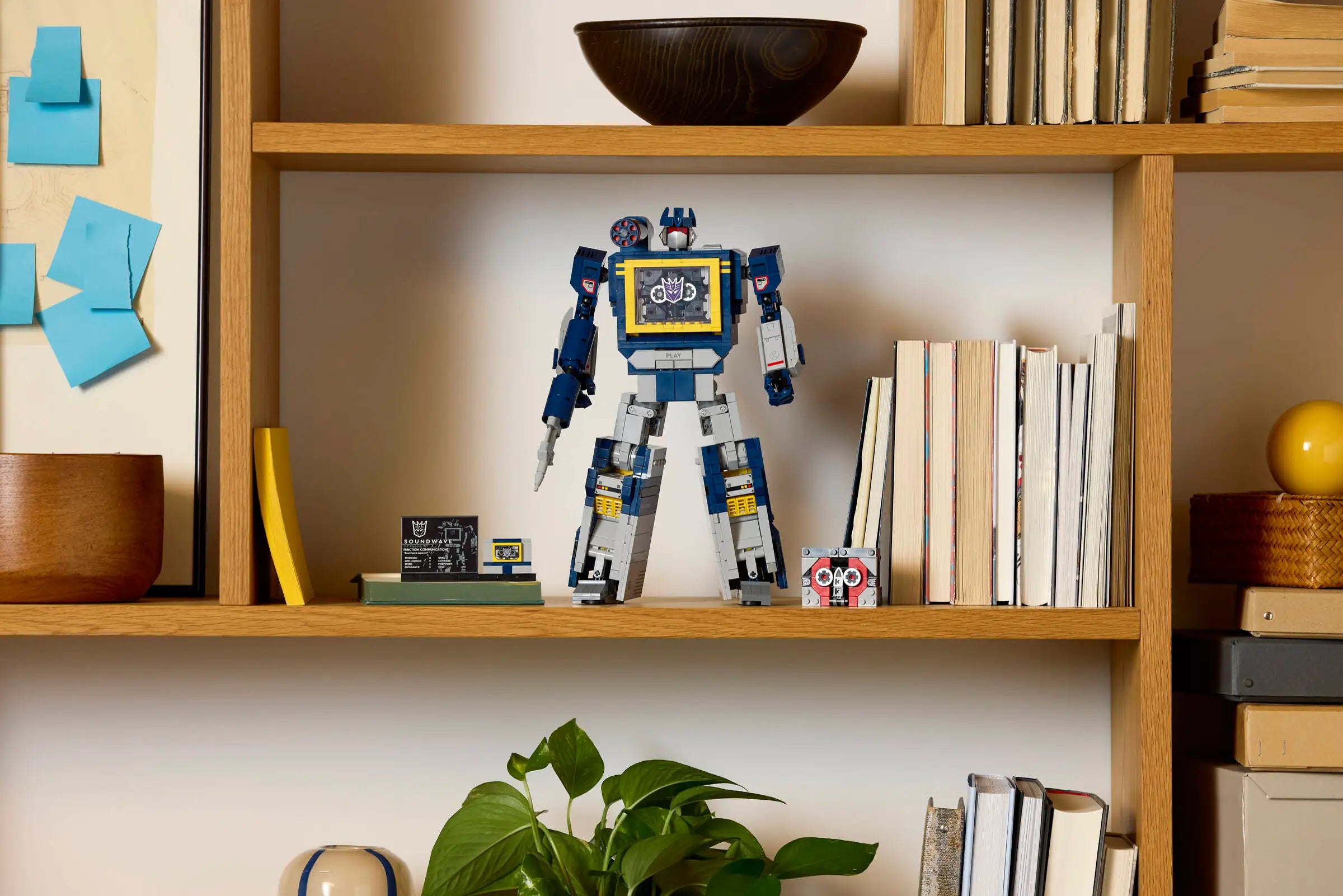 LEGO 10358 Transformers: Soundwave on a wooden shelf with books and decorative items