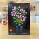 LEGO Botanicals 10372 Hibiscus set packaging with a purple flower tree design on a blurred background.