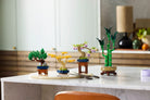 Set of LEGO miniature bonsai tree models on a marble surface with a blurred background