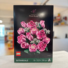 LEGO Botanicals 10374 Bouquet of Pink Roses set packaging with pink roses on a blurred indoor background