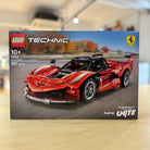 LEGO 42212 Ferrari FXX K model kit packaging on a wooden surface with blurred background