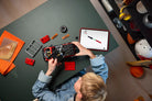 Child assembling a LEGO 42213 Ford Bronco SUV on a table with tools and parts