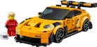 LEGO 77239 Porsche 911 GT3 RS - Yellow sports car model made of interlocking bricks with a small figure next to it on a white background