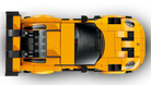 Top-down view of a LEGO 77239 Porsche 911 GT3 RS yellow sports car model made from interlocking bricks on a white background
