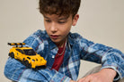 Child holding a LEGO 77239 Porsche 911 GT3 RS yellow toy car against a neutral background