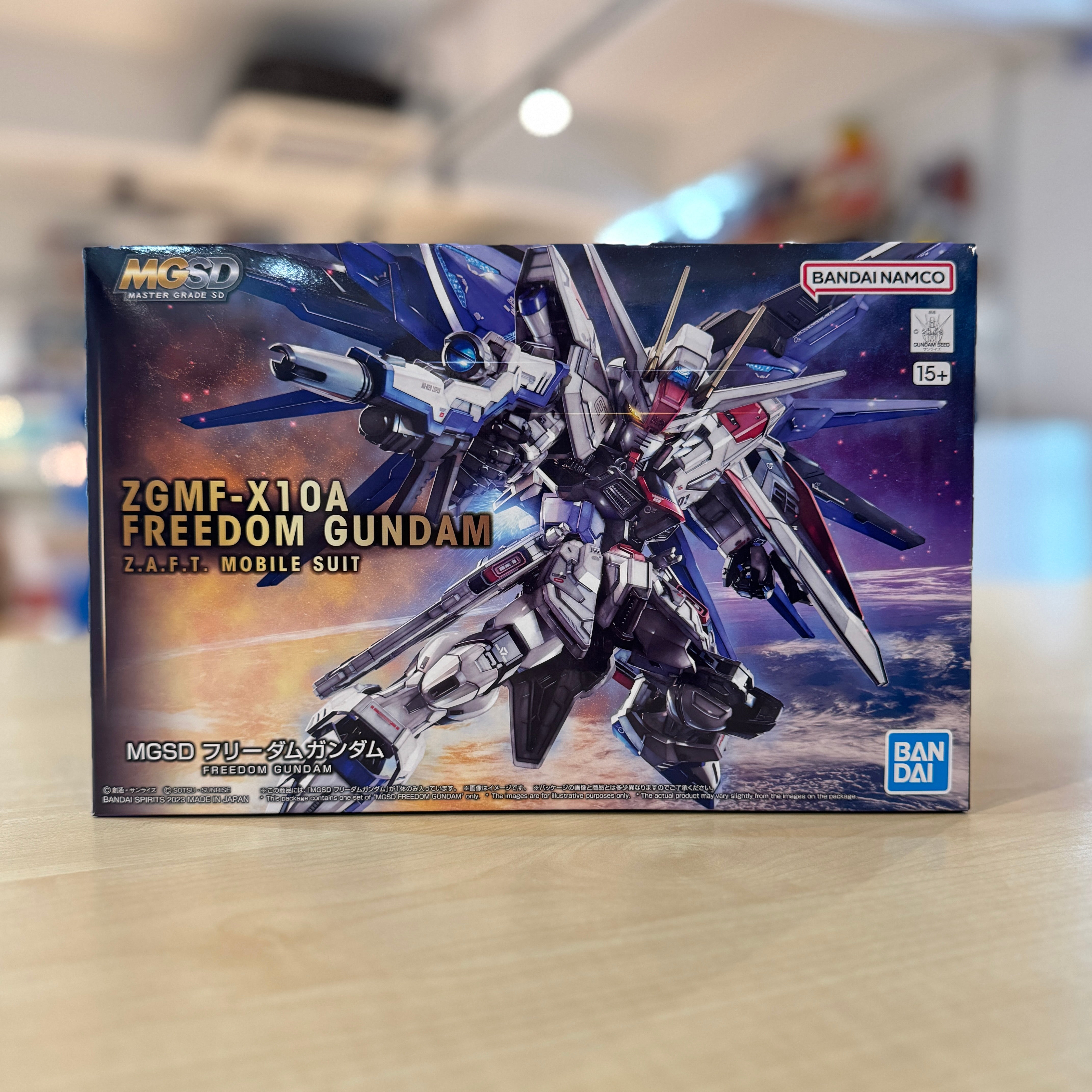 Boxed model kit of MGSD Freedom Gundam by Bandai Namco on a blurred background